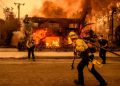 Firefighters work as an apartment building burns in the Altadena area of Los Angeles county / ©AFP