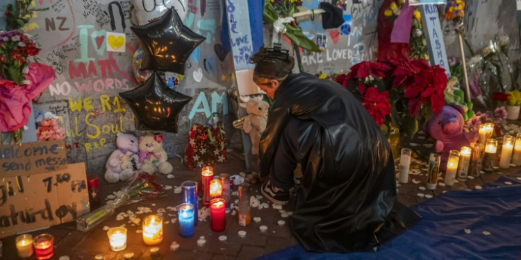 Mourners hold a vigil on Bourbon Street for the 14  victims killed in a January 1, 2025 truck-ramming attack in New Orleans, Louisiana. ©AFP