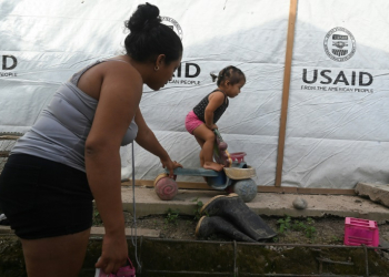 Sandra Ramos plays with her daughterat an improvised shack built with the help of the US Agency for the International Development (USAID) following hurricanes in in La Lima, Honduras, in July 2022. ©AFP