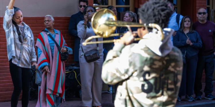 Samantha Petry (L) dances after placing flowers at a memorial on Bourbon Street . ©AFP