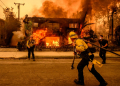 Firefighters work as an apartment building burns in the Altadena area of Los Angeles county. ©AFP