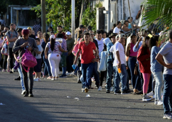 Migrants seeking permits allowing them to travel to the US border wait outside an immigration office in southern Mexico . ©AFP