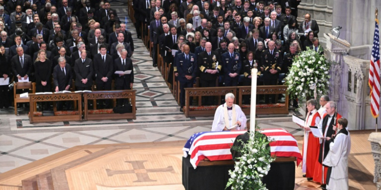 Members of the clergy pray over the casket of former US president Jimmy Carter during his state funeral at Washington National Cathedral, as all five living US presidents look on. ©AFP