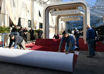 Workers unroll the red carpet ahead of the Golden Globes . ©AFP