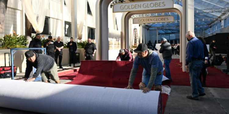 Workers unroll the red carpet ahead of the Golden Globes . ©AFP