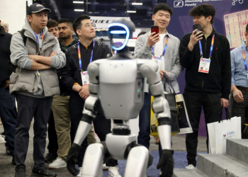 Attendees watch as a robot walks around during a demonstration at the Unitree Robotics booth during the Consumer Electronics Show (CES) in Las Vegas. ©AFP