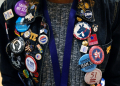 A woman shows off her button and pin collection during day one of the Democratic National Committee 2023 Winter meeting / ©AFP