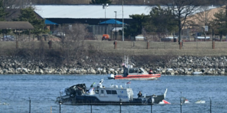 A police boat gathers wreckage along the Potomac River after American Airlines flight 5342 collided with a US Army helicopter. ©AFP