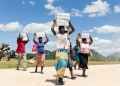 Mothers carry boxes of porridge backed by US aid in the Mutokoarea of Zimbabwe in 2019 as drought worsened hunger  / ©AFP